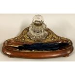 A Victorian mahogany and brass desk stand, with an octagonal glass inkwell, raised on three ball