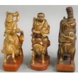 Three Chinese carved and gilded wooden finials, Qing dynasty, a scholar mounted on a dragon, a man
