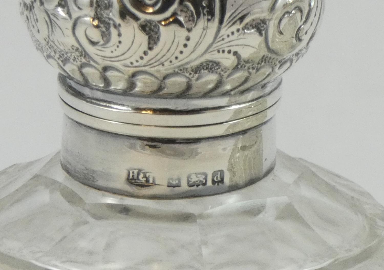 A pair of silver capped cut glass scent bottles, Birmingham 1904, the embossed hinged covers (one - Image 2 of 2