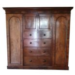 A 19th century mahogany wardrobe, the central cupboard over four graduated drawers, the right