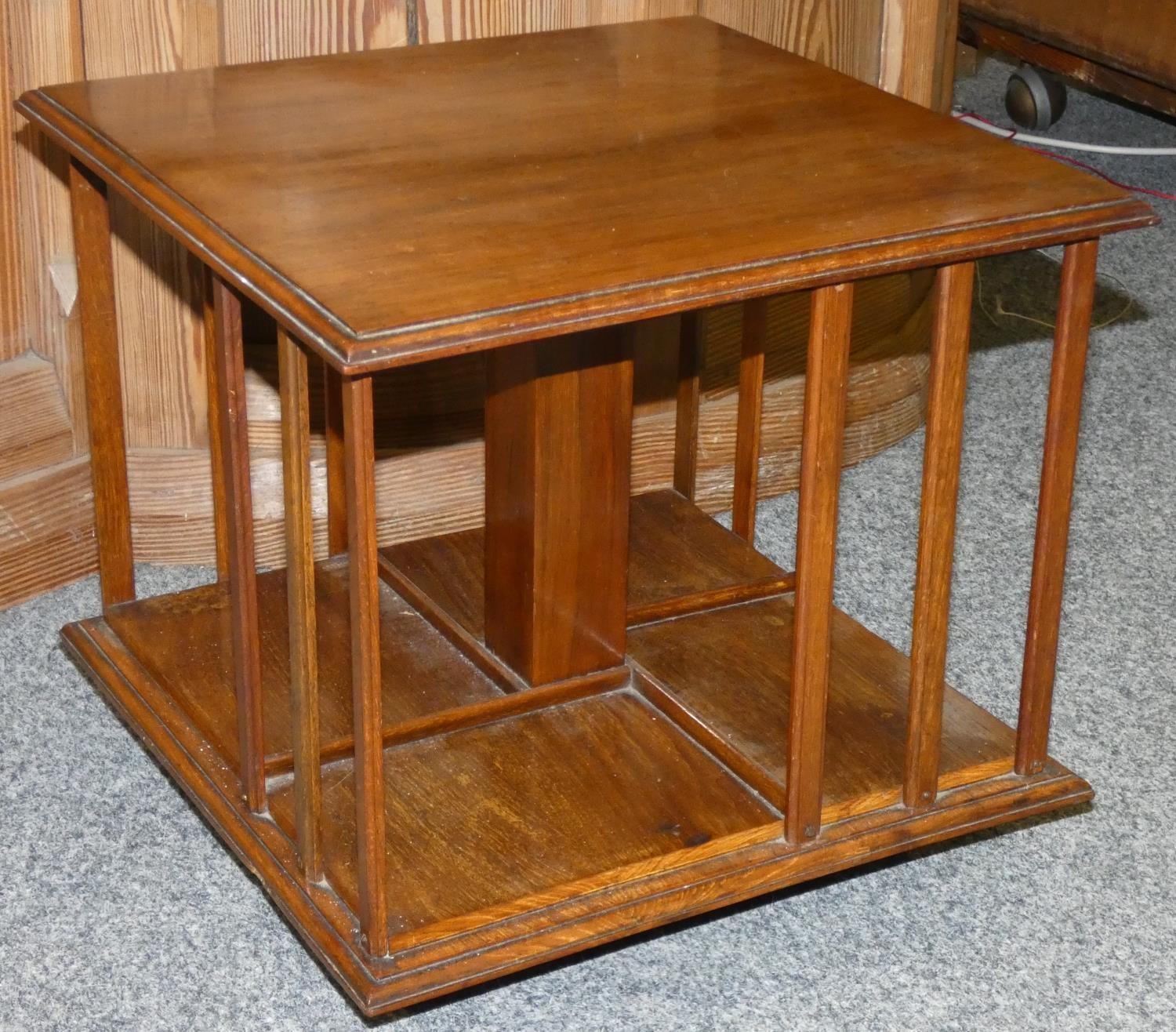 An Edwardian mahogany table top revolving bookcase, with thumb nail edge, raised on a spreading