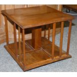 An Edwardian mahogany table top revolving bookcase, with thumb nail edge, raised on a spreading