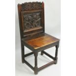 An 18th century carved oak hall chair, with floral decorated back and stretcher supports, 95 cm.
