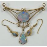 A 9ct gold and opal doublet brooch, collet set with a circular stone in an openwork mount, drop