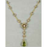 A Victorian peridot and pearl necklace, c. 1880, the pear shape drop suspended from a natural and