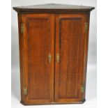 A 19th century oak corner cupboard, the single door opening to reveal shaped shelves, 93 x 71 x 39