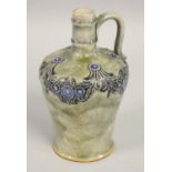 A Royal Doulton wine jug with tubeline flower decoration to the neck, on a mottled green ground,