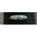 A white metal, probably platinum and diamond half eternity ring, set with nine brilliant cut stones,