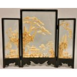 A Chinese carved wood triptych, depicting pagodas, storks and trees, glazed panels, height 25 cm.