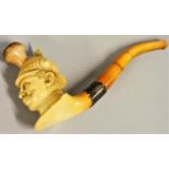 A meerschaum pipe, carved to depict Kaiser Wilhelm II with helmet, silver mount, amber pipe