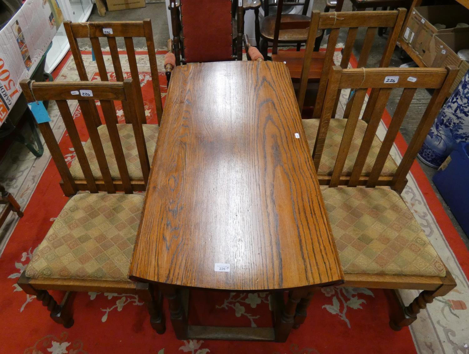 An oval drop leaf gate leg dining table, 150 x 110 cm, together with four chairs with drop in