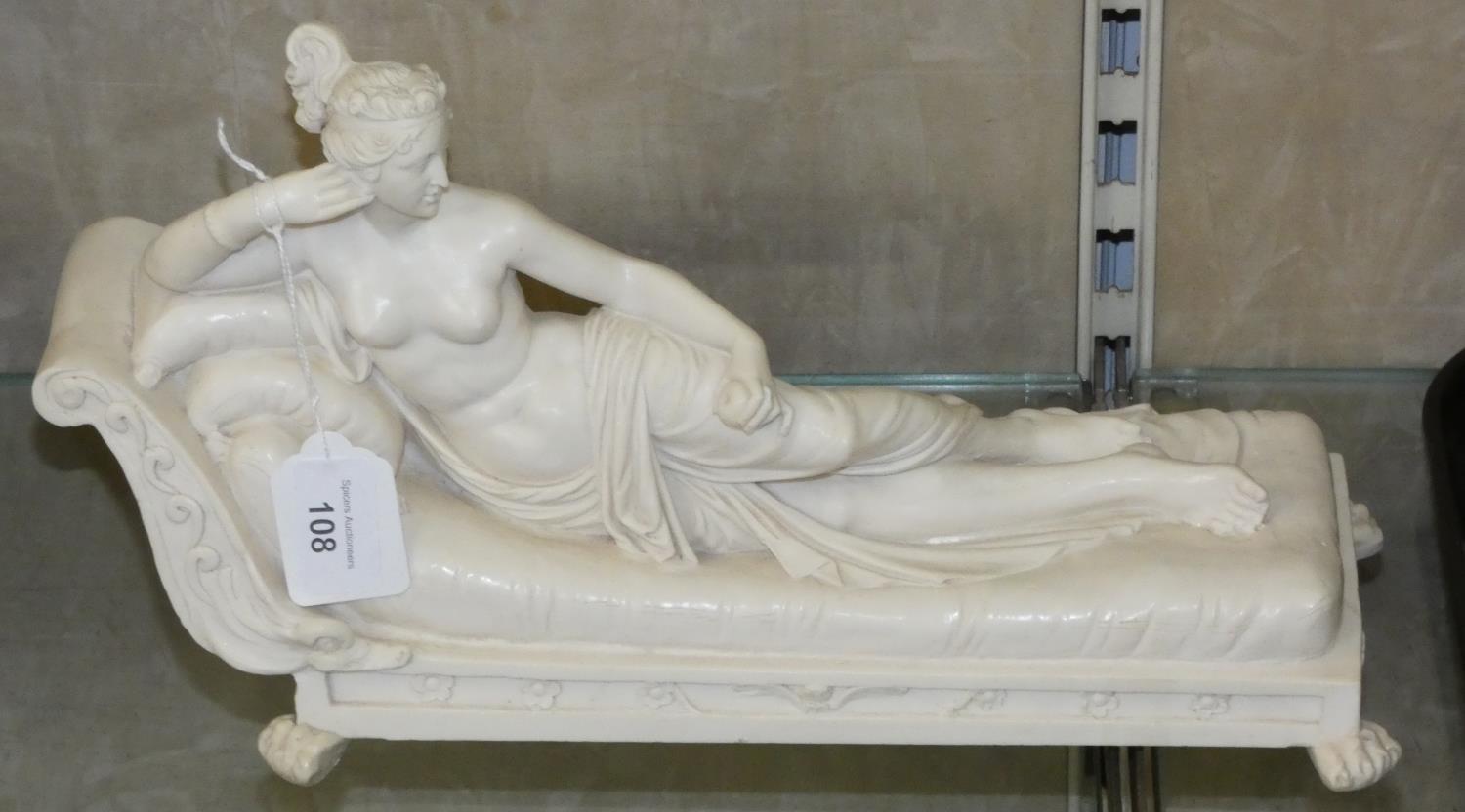 A semi-nude lady made of resin reclining on a chaise longue, indistinctly signed, length 35cm.