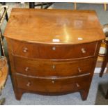 A bow fronted oak three height chest of drawers, 69cm tall, 63cm long, 40cm deep.