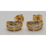 A pair of silver gilt and diamond earstuds, channel set with three rows of baguette cut stones,