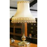 A brass effect column table lamp with gold fringed tasseled shade.