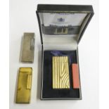 A Dunhill 70 cigarette lighter, case, paperwork, another cased Dunhill lighter and a third, uncased.