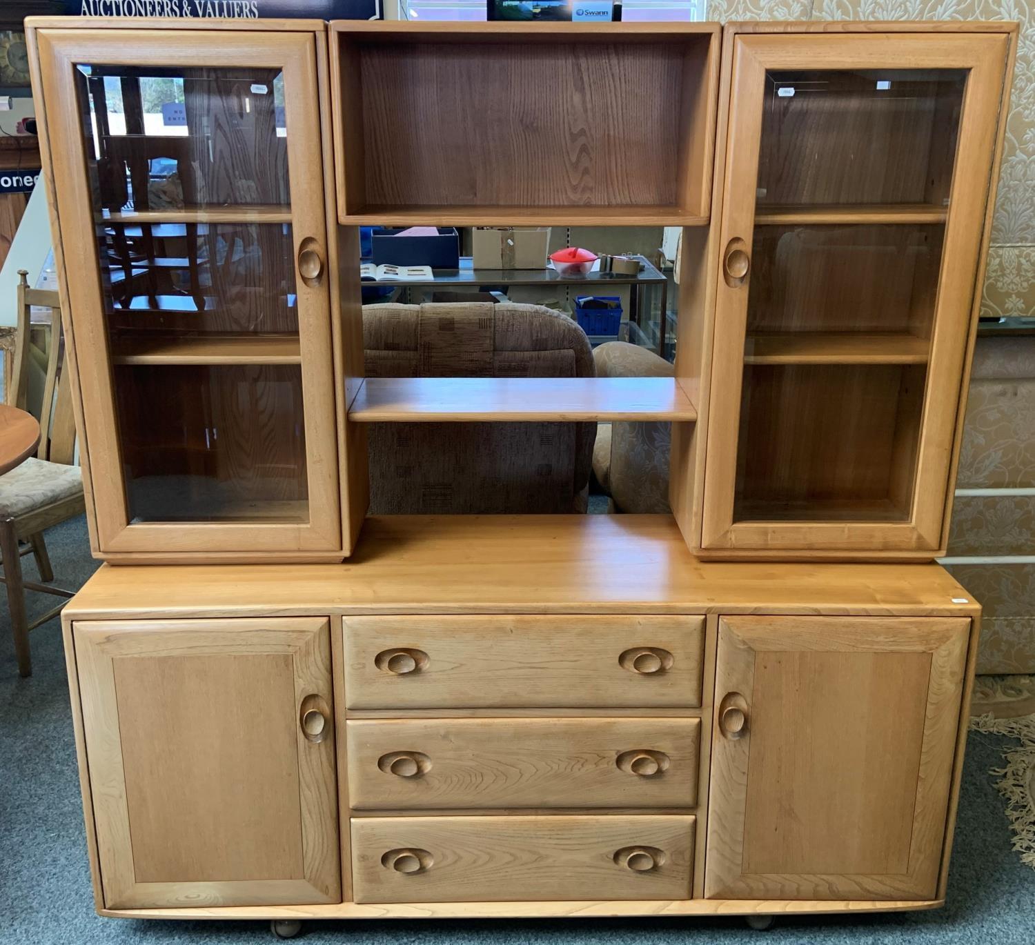 An Ercol beech wall unit 156 x 162 cm, the top with display shelves to either side behind glazed