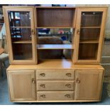 An Ercol beech wall unit 156 x 162 cm, the top with display shelves to either side behind glazed
