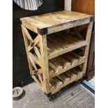 An industrial style wine rack/island unit, with metal straps and wheels, 60 x 41 x 90 cm.