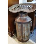 An industrial style milk churn with tractor seat.