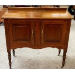 A stained wood washstand, raised on brass castors.