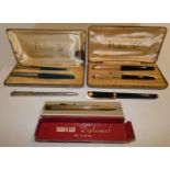 A Parker 51 fountain pen and biro, with gilt covers and black body, case another set in chrome and