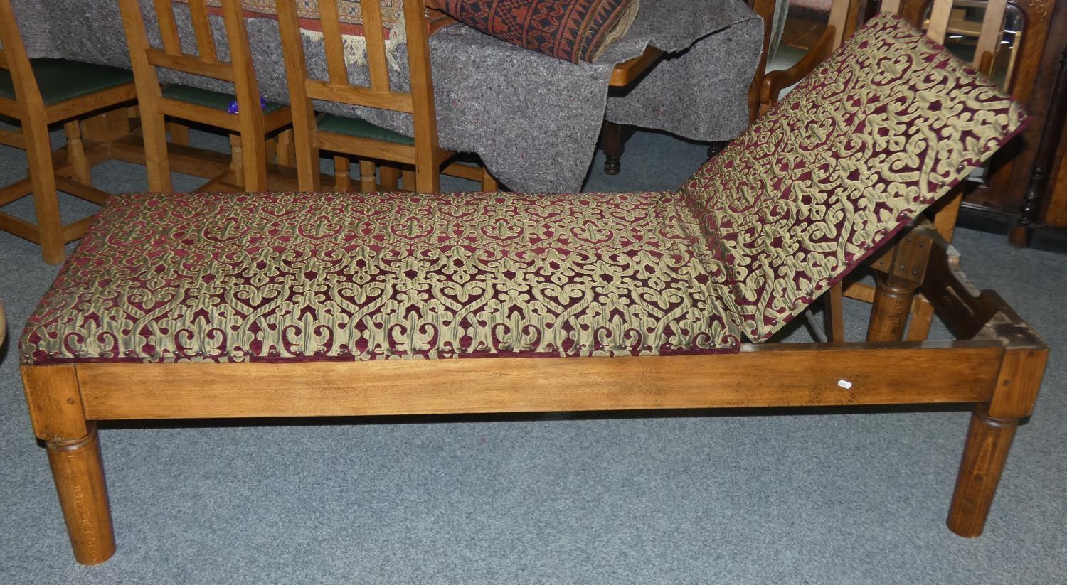 An Edwardian stained pitch pine day bed with adjustable back rest in red and gold fabric 185 cm