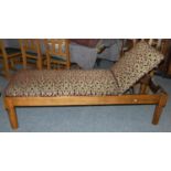 An Edwardian stained pitch pine day bed with adjustable back rest in red and gold fabric 185 cm