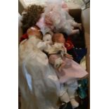 A vintage crawling wind up baby doll, lacking left leg and two boxes of various dolls including,