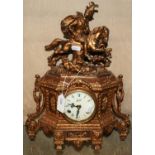 A gilt brass mantle clock featuring figure on horse with dog to the top.