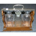 A 3 bottle Tantalus with 2 matching decanters (locked).