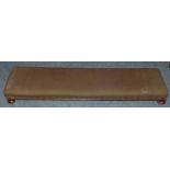 A long Victorian footstool 125 cm wide in brown fabric.