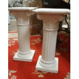 A pair of painted pottery Corinthian columns, 56 cm.