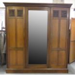 A mahogany triple wardrobe with central mirrored door (pin attachment), the left side 'double'