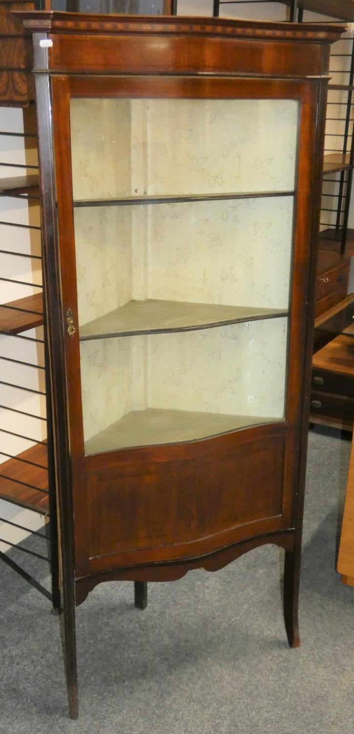An Edwardian mahogany corner display cabinet with boxwood inlay, serpentine glass door, lined