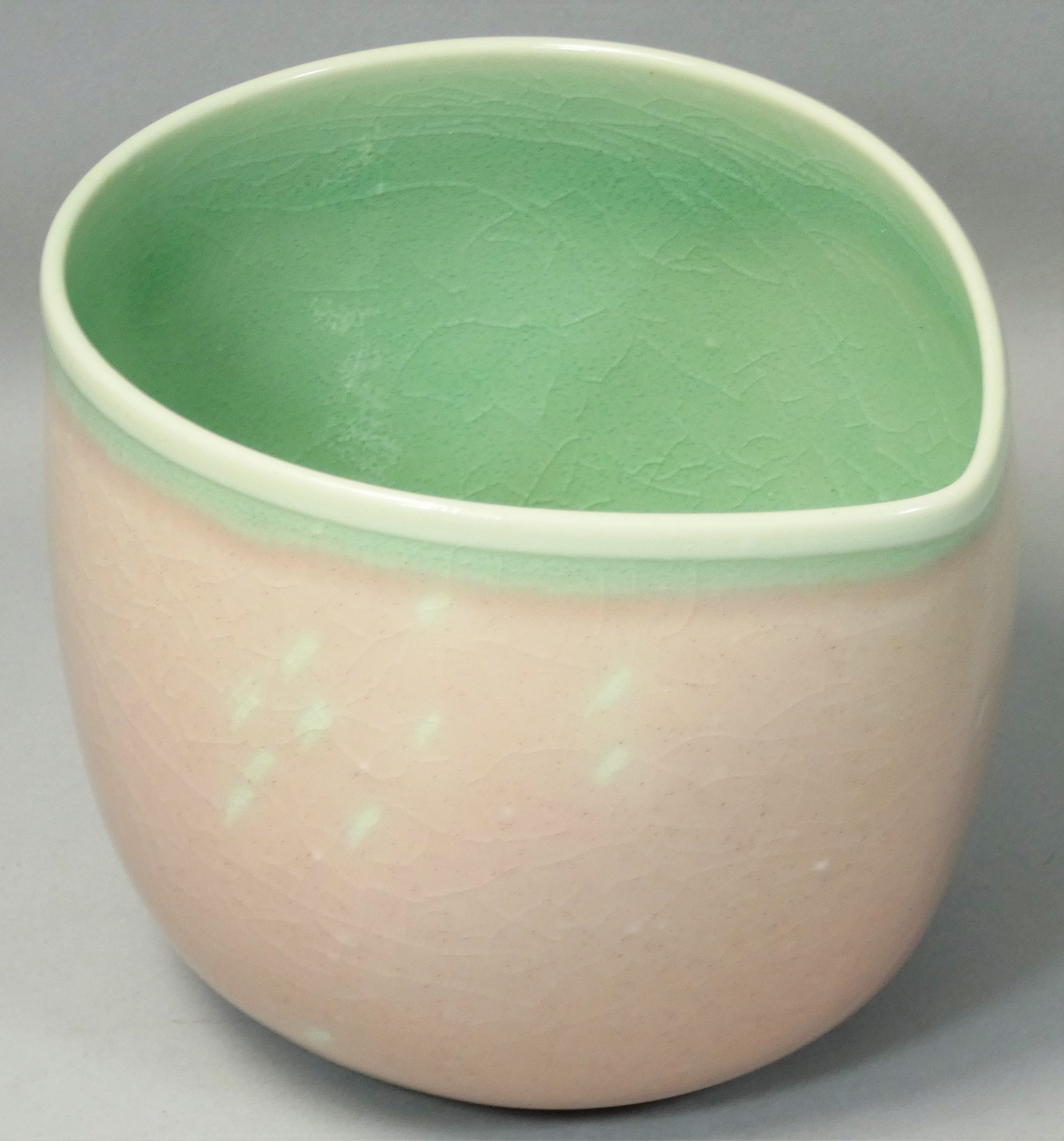 Caroline Whyman, a crackle glazed pouring jug in light pink glaze, celadon interior and rim,