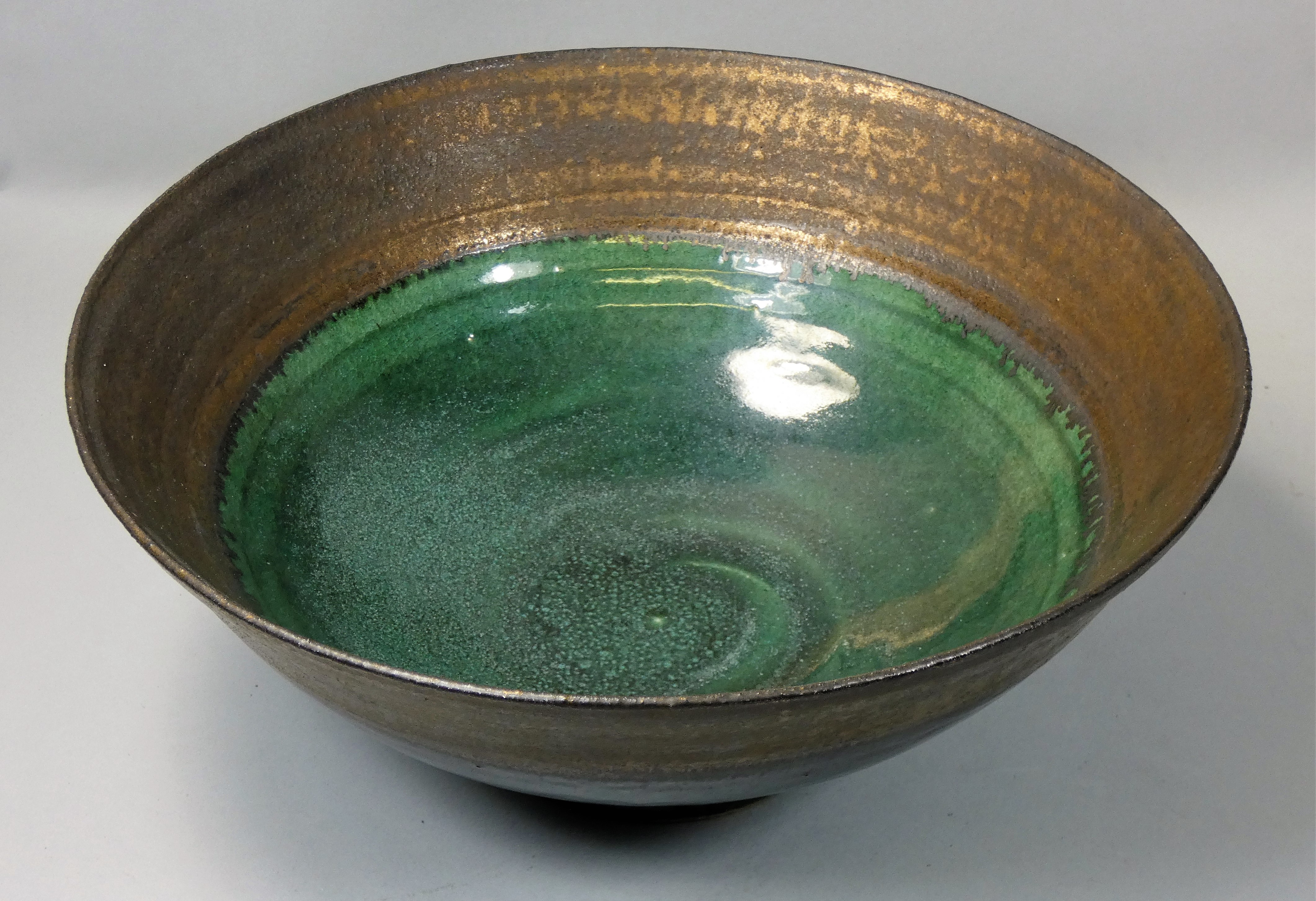 Nick Booth (contemporary), a large studio pottery bowl, with brass patinated rim and polychrome