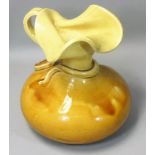 J R Mally, an 'Old London Ware' studio art pottery distorted yellow squat vase, in the form of a jug