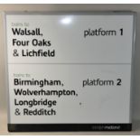 A modern station platform destination sign with various towns and cities listed to include,