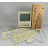 An early Macintosh SE personal computer, together with three keyboards (one boxed), mouse, power