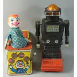 A vintage battery operated robot made in Japan, together with a Mattel tinplate Jack-In-The-Music-