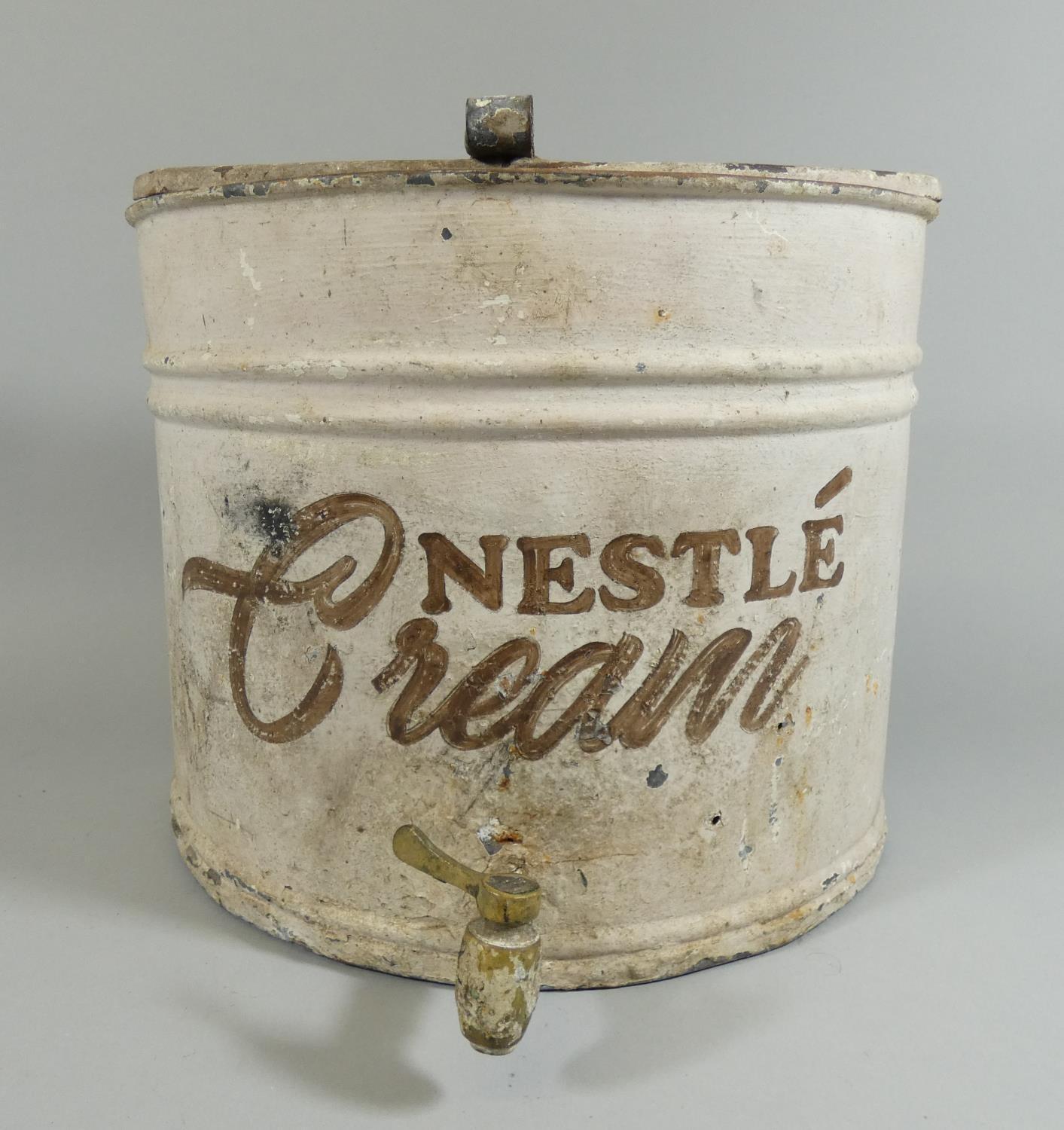 A 'Nestle Cream' tin container of semicylinder form, with tap to the front, height 25cm.