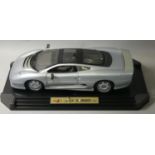 A boxed Maisto model of a Jaguar XJ220 (1992) race car, 1:12 scale, finished in metallic silver,