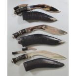 An Indian Kukri, the chrome blade with prick dot decoration, two small knives to the scabbard and