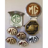 A collection of MG badges, including a T Register bumper badge and four brown and enamel centres.