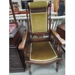 A late Victorian stained frame armchair having adjustable slant back with pillar and carved