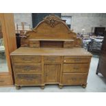 A Victorian scumbled pine dresser base having arch raised back with shelf and drawers over central