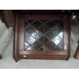 An early 20th century mahogany corner wall cupboard of small size having leaded glass door