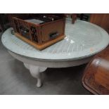 A large shabby chic painted circular coffee table, woven top under glass on cabriole legs
