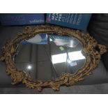 A vintage gilt scroll frame mirror